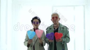 可爱的亚洲老年夫妇<strong>蹦蹦</strong>跳跳的心脏气球玩得很开心